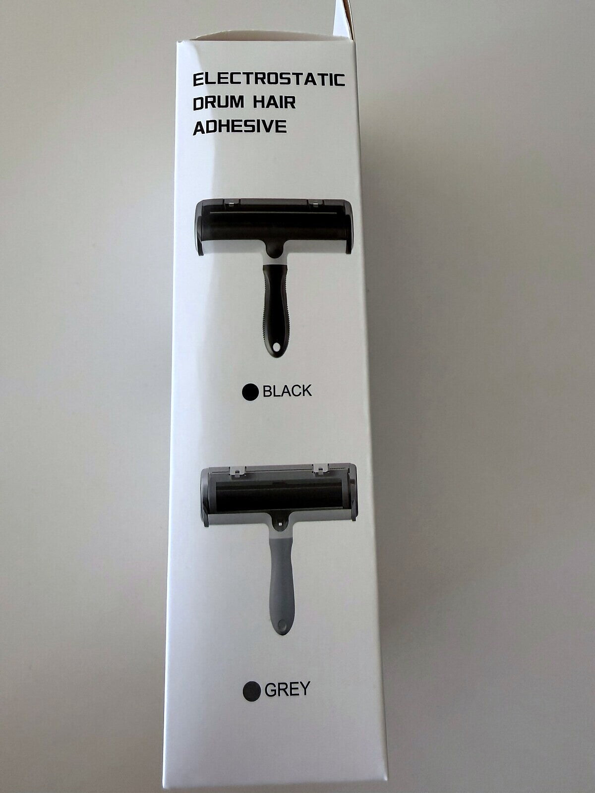 AZAY pet hair remover colour panel printed on the box, showing the Black unit and the light unit. The packaging labels the light one GREY; this listing calls it Cream White. Same product.